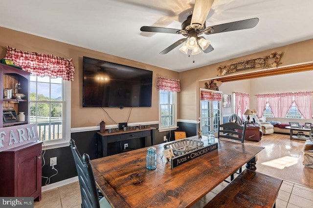 dining area featuring a ceiling fan, baseboards, and light tile patterned flooring