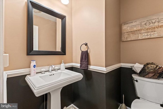 half bath featuring toilet and a sink