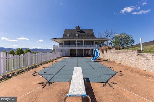 view of pool featuring a fenced backyard, a water slide, a fenced in pool, and a patio