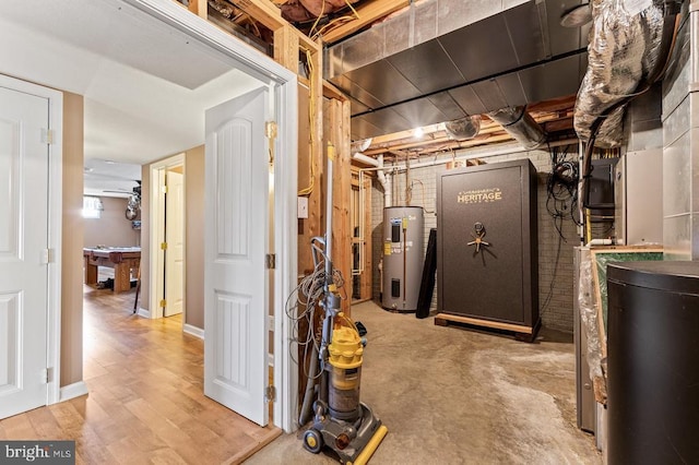 unfinished below grade area featuring water heater and wood finished floors