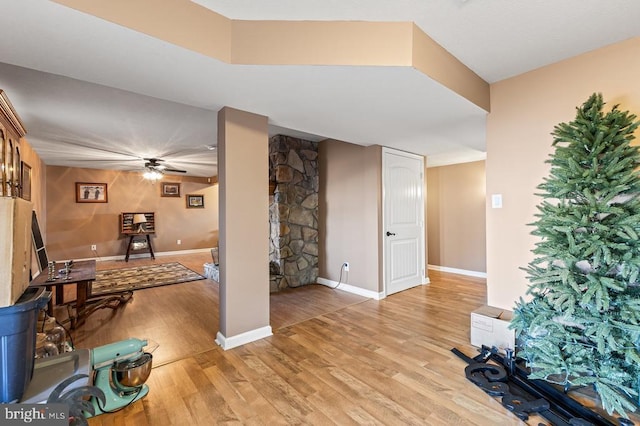 interior space with light wood-type flooring, baseboards, and ceiling fan