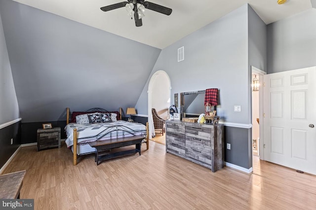 bedroom featuring lofted ceiling, baseboards, light wood-style flooring, and visible vents