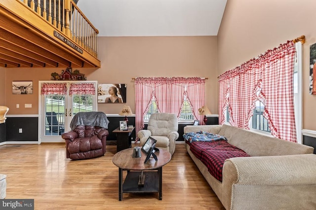 living area featuring a high ceiling, a healthy amount of sunlight, and wood finished floors