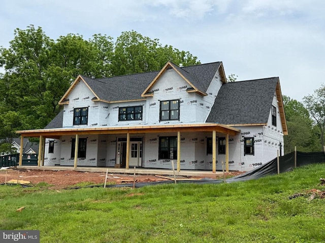  - view of front facade with roof with shingles, a front lawn, and a patio