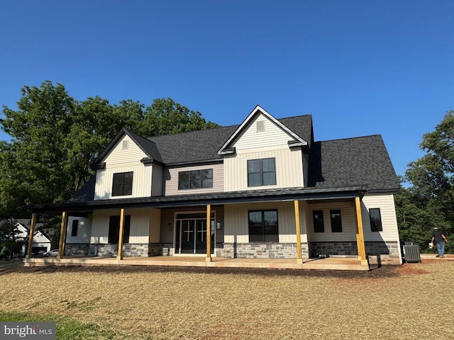  - modern farmhouse featuring covered porch, stone siding, and a shingled roof