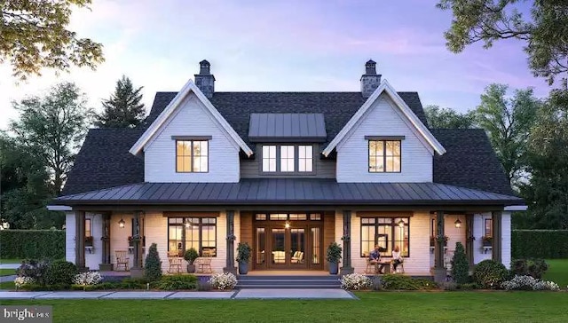  - back of house with covered porch, a standing seam roof, a yard, and metal roof