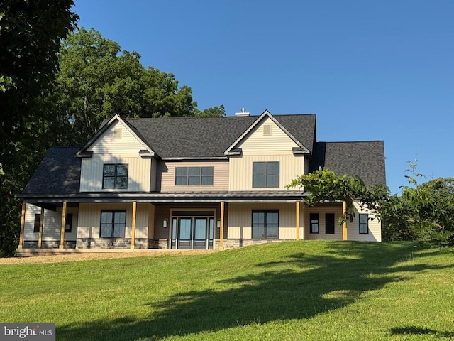  - back of house featuring a lawn, a porch, stone siding, and roof with shingles