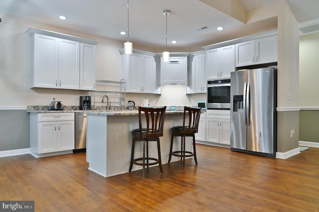 1835 Mill Creek Xrds, Luray, VA 22835 - kitchen with appliances with stainless steel finishes, dark wood-style floors, a kitchen breakfast bar, recessed lighting, and a center island