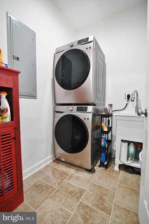 1835 Mill Creek Xrds, Luray, VA 22835 - laundry area with stacked washing machine and dryer, electric panel, and stone finish floors