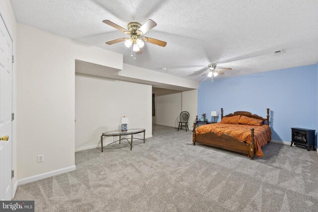 468 George James Loop, Radiant, VA 22732 - carpeted bedroom featuring a wood stove, a textured ceiling, visible vents, a ceiling fan, and baseboards