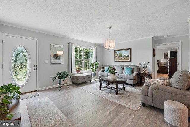  - living room featuring a textured ceiling, light wood finished floors, a chandelier, and crown molding