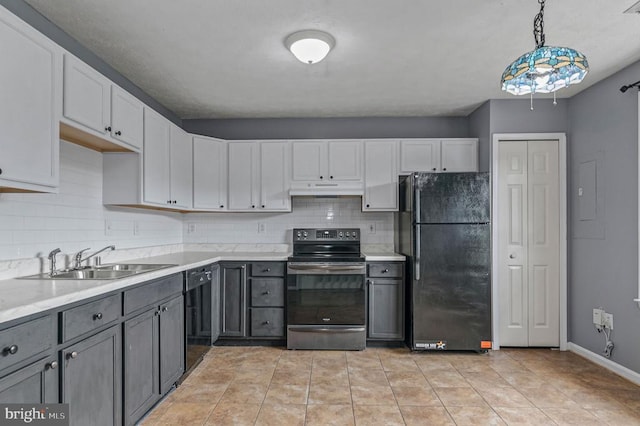 kitchen with black appliances, under cabinet range hood, a sink, tasteful backsplash, and light countertops