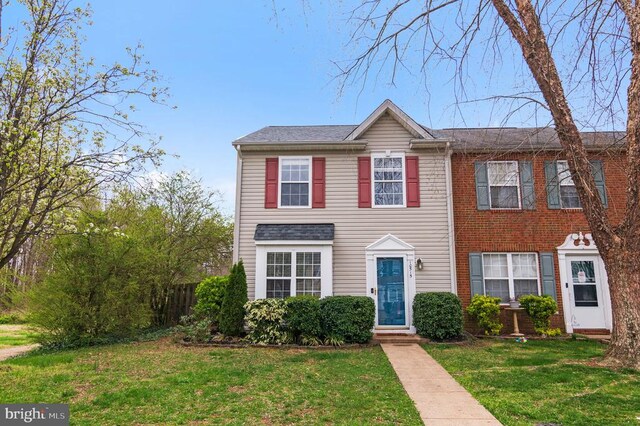 view of front of home with a front lawn and brick siding