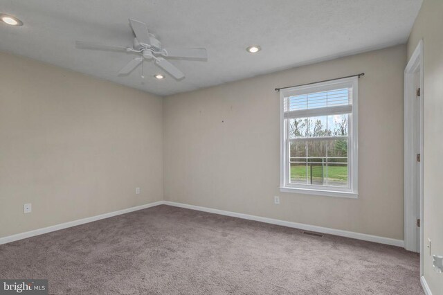 carpeted spare room featuring recessed lighting, baseboards, and a ceiling fan