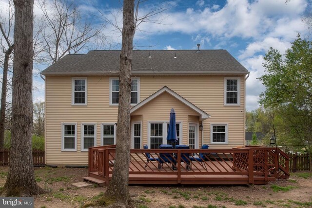 rear view of property with a deck and fence