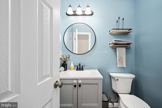 half bathroom featuring toilet and vanity