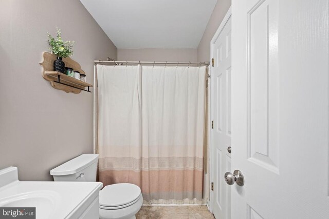 full bath featuring toilet, a shower with shower curtain, and vanity
