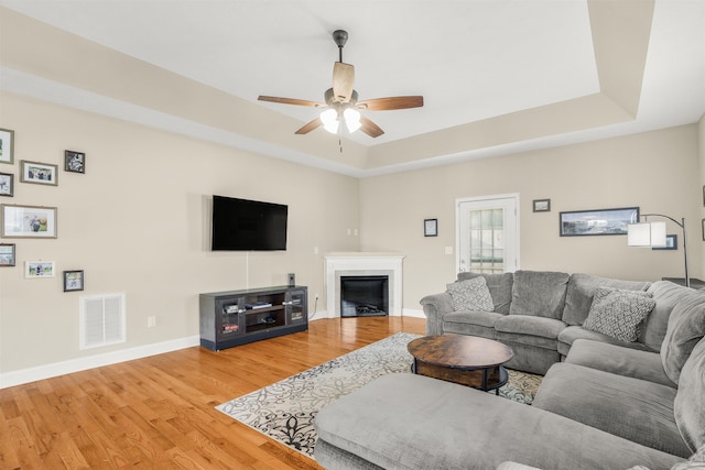 109 Beauregard Dr, Staunton, VA 24401 - living area featuring a tray ceiling, wood finished floors, a ceiling fan, and a glass covered fireplace
