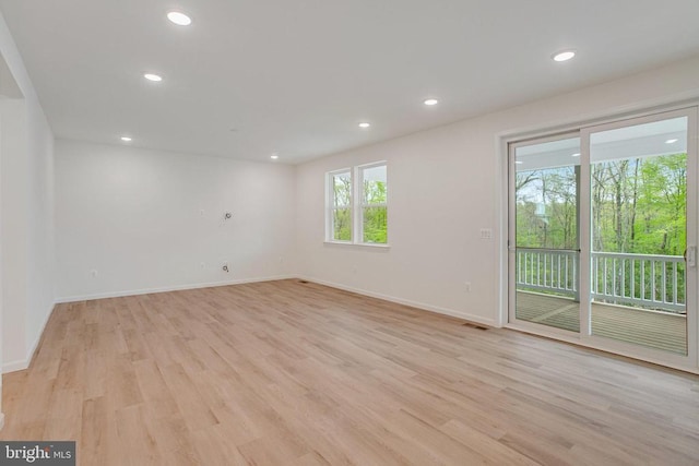 unfurnished room with light wood finished floors, baseboards, and recessed lighting