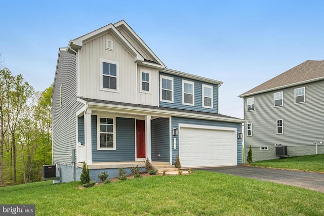 traditional home featuring covered porch, asphalt driveway, a front yard, board and batten siding, and an attached garage