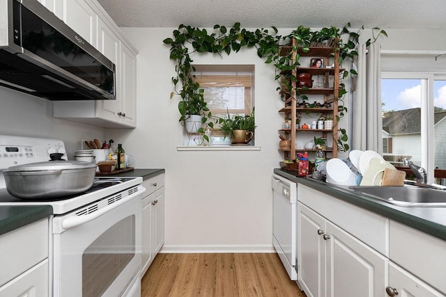 2387 King Arthurs Ct, Harrisonburg, VA 22801 - kitchen with white appliances, light wood finished floors, a textured ceiling, a sink, and dark countertops