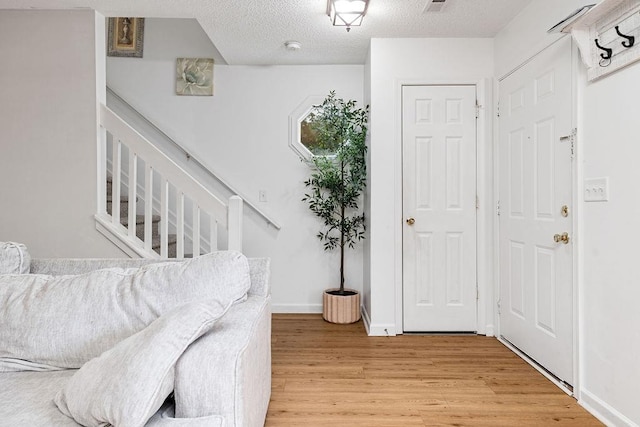 2387 King Arthurs Ct, Harrisonburg, VA 22801 - foyer with light wood-type flooring, a textured ceiling, baseboards, and stairs
