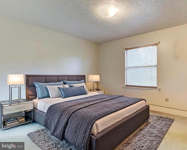 carpeted bedroom with baseboards and a textured ceiling