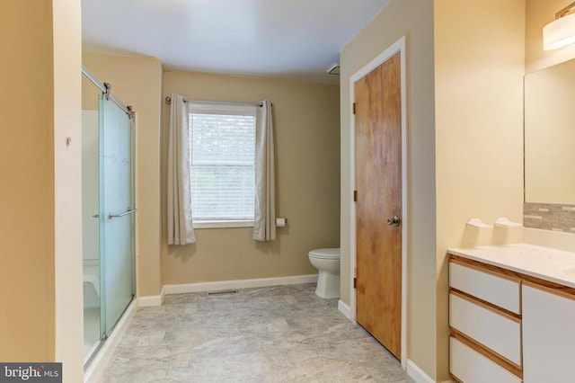 bathroom featuring vanity, baseboards, toilet, and a stall shower