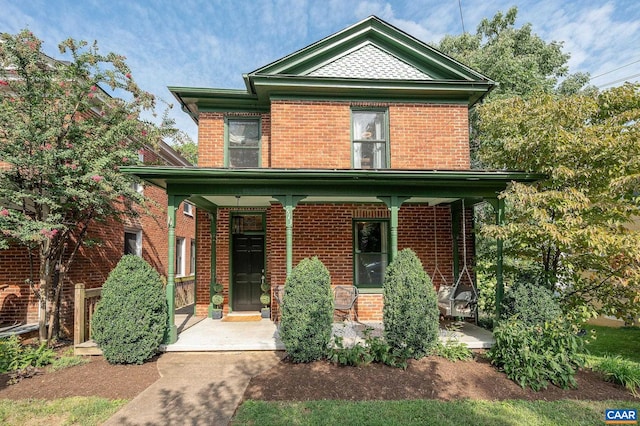 view of front of home with covered porch and brick siding