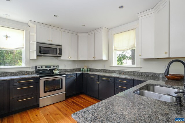 kitchen featuring stainless steel appliances, a sink, healthy amount of natural light, white cabinetry, and recessed lighting