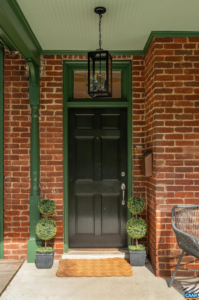 property entrance with brick siding and a porch