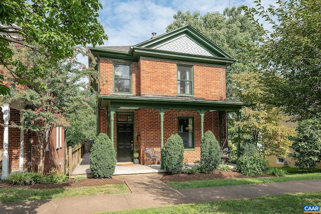 view of front of home with a porch and brick siding