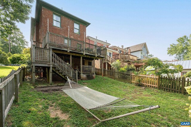 back of property with stairway, a wooden deck, and brick siding
