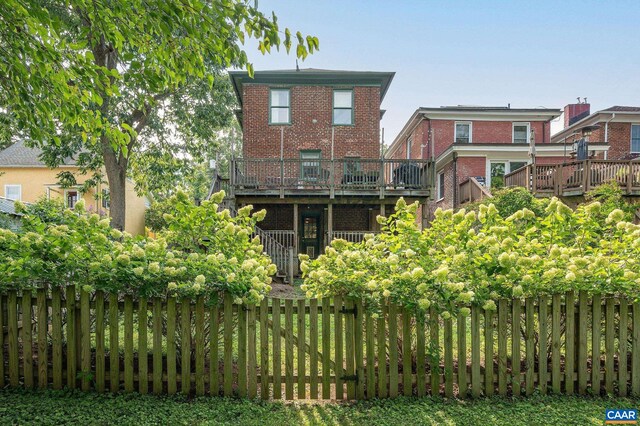 back of house featuring a wooden deck and brick siding