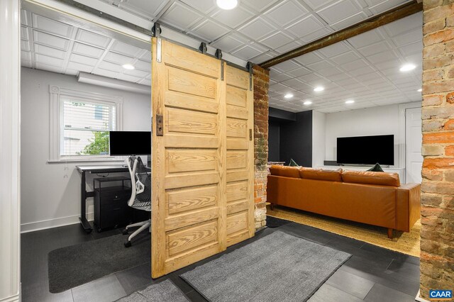 living room featuring a barn door, recessed lighting, an office area, and baseboards