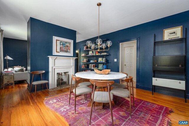 dining space with wood finished floors and a fireplace with flush hearth