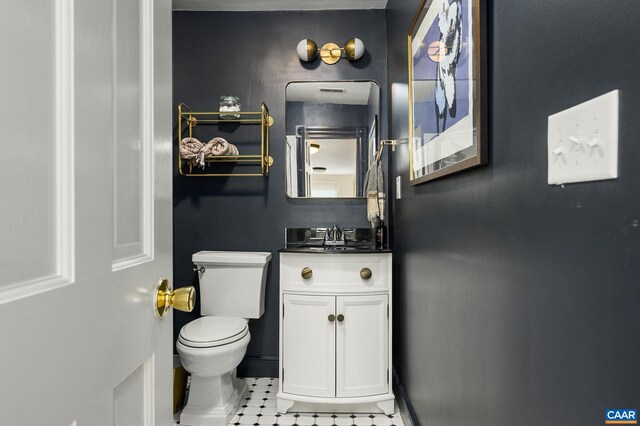 bathroom featuring toilet, vanity, and baseboards