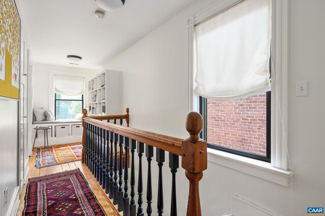 hall with an upstairs landing and wood finished floors