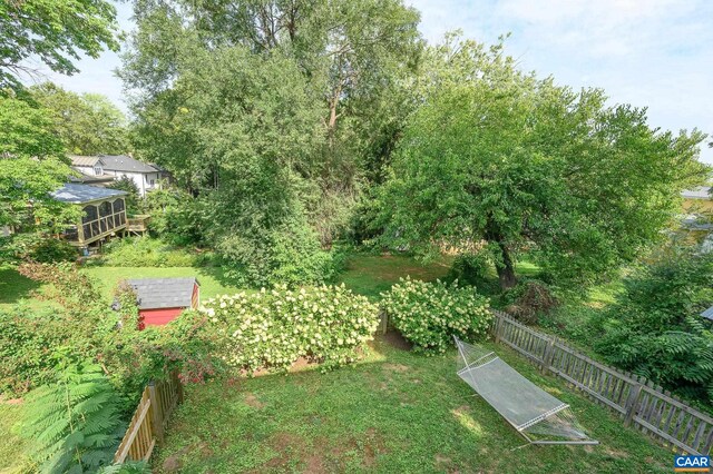 view of yard with fence, a storage shed, and an outbuilding
