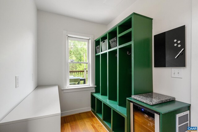 mudroom featuring light wood-style floors, baseboards, and wine cooler