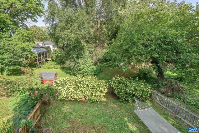 view of yard featuring fence, a shed, and an outbuilding