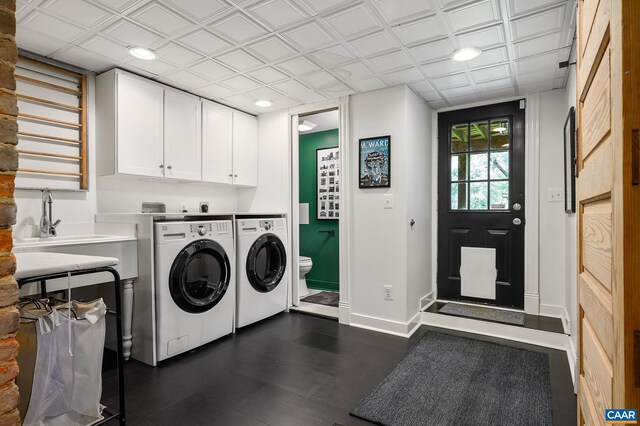 clothes washing area with washing machine and dryer, baseboards, recessed lighting, and dark wood finished floors