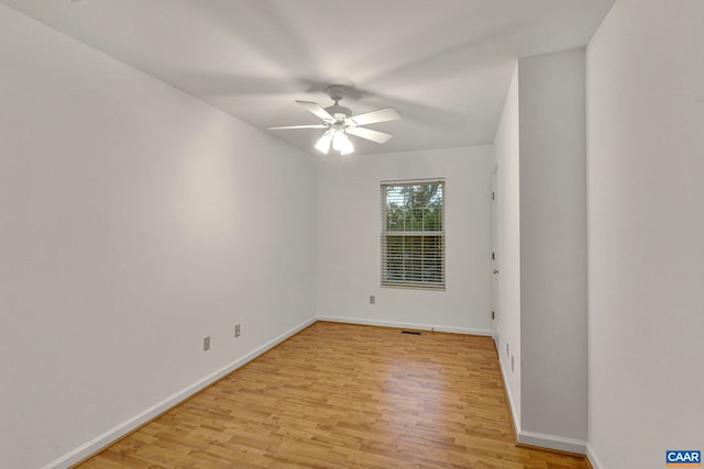 empty room featuring light wood finished floors, baseboards, and ceiling fan