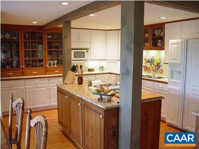 301 Gillums Ridge Rd, Charlottesville, VA 22903 - kitchen featuring white cabinetry, paneled fridge with ice dispenser, white microwave, and glass insert cabinets
