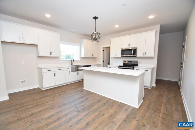 kitchen with white cabinets, a center island, stainless steel appliances, and a sink