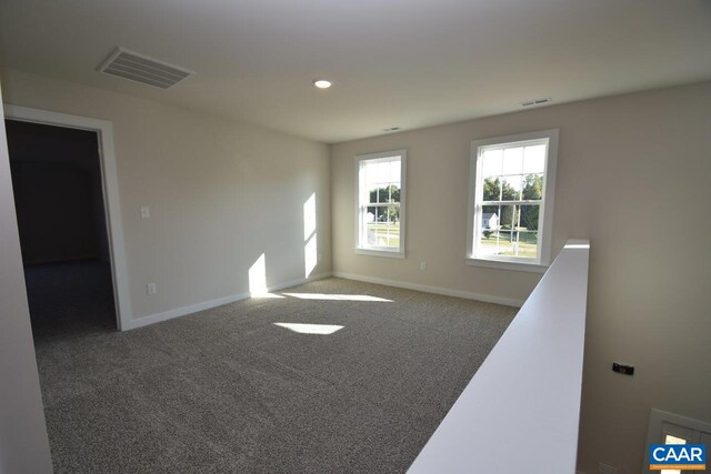 spare room with baseboards, recessed lighting, visible vents, and carpet