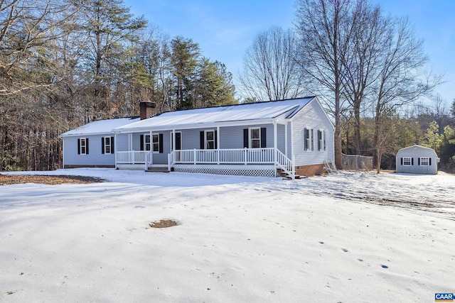 view of front of house featuring a porch and a storage shed