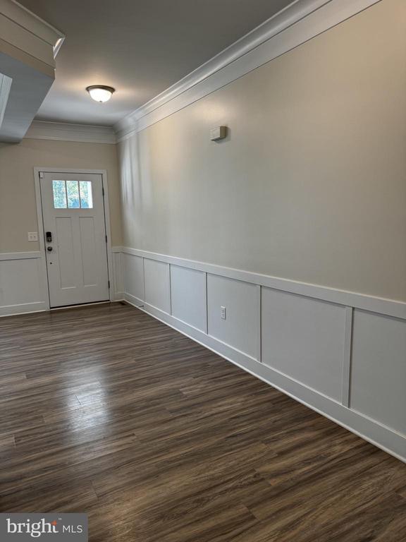 102 Monroe St, Locust Grove, VA 22508 - foyer featuring crown molding, a decorative wall, dark wood finished floors, and a wainscoted wall