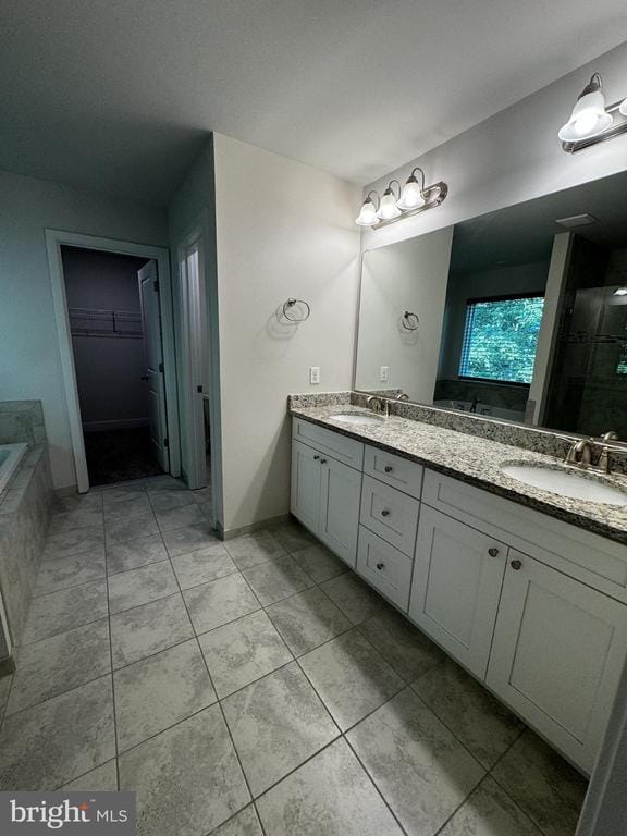 102 Monroe St, Locust Grove, VA 22508 - full bathroom with double vanity, tile patterned floors, a shower stall, tiled bath, and a spacious closet