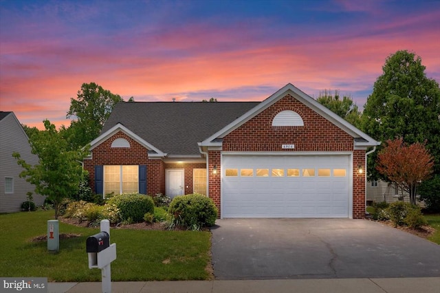 traditional-style house featuring asphalt driveway, brick siding, and a front yard